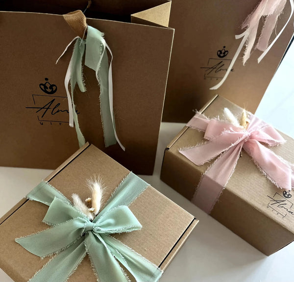 Kraft gift boxes tied with green and pink ribbons