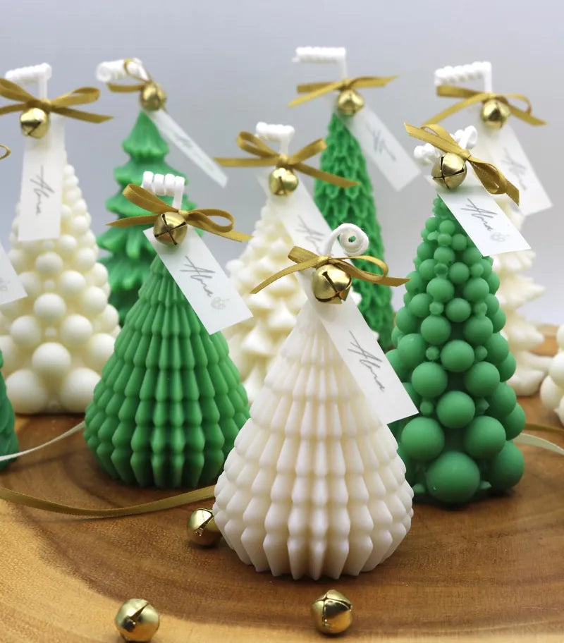 Ivory and green Christmas tree candles with gold bells and Alma tags on a wooden board
